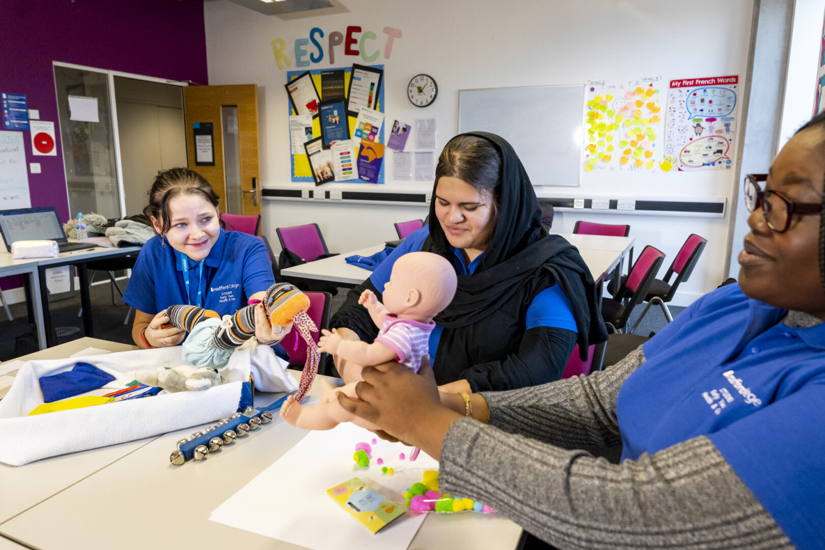 health and social care students sat holding baby dolls as they sit in a classroom