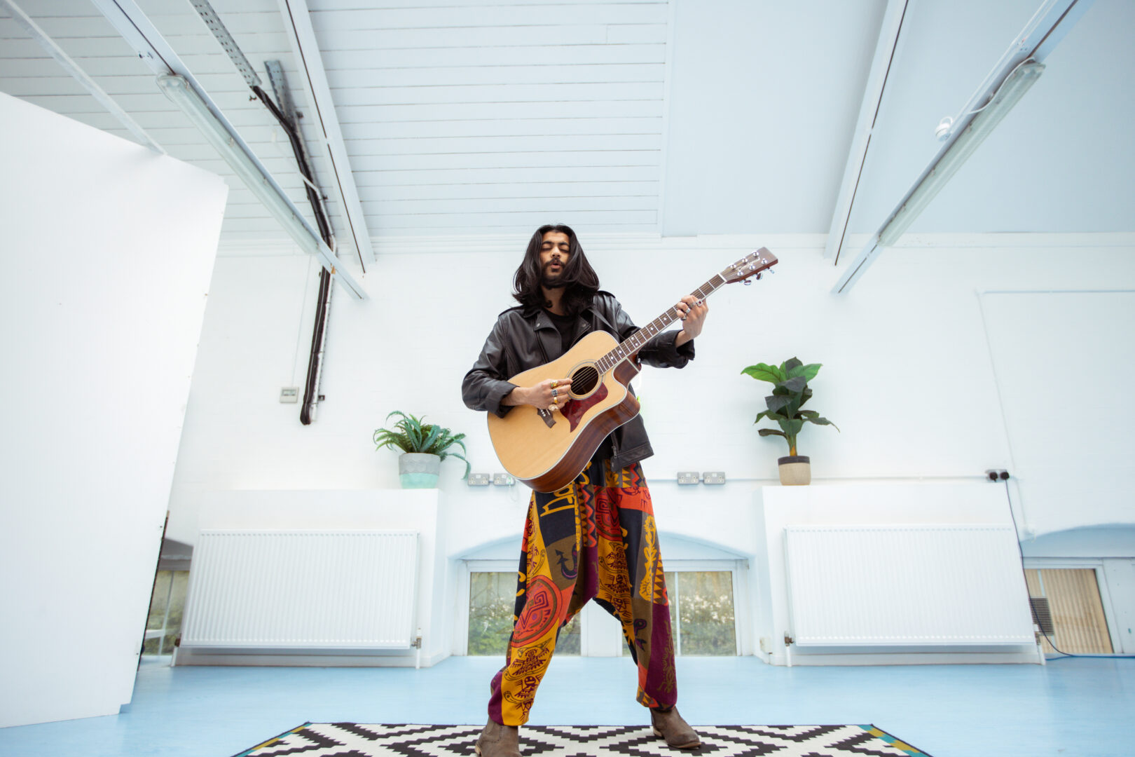 an image of a music student holding a guitar and performing