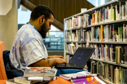 student sat working at a laptop in our library facilities