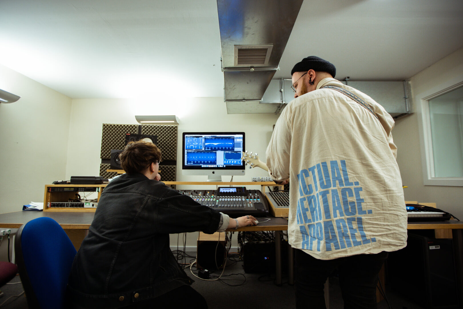 two music students stood working at a mixing desk