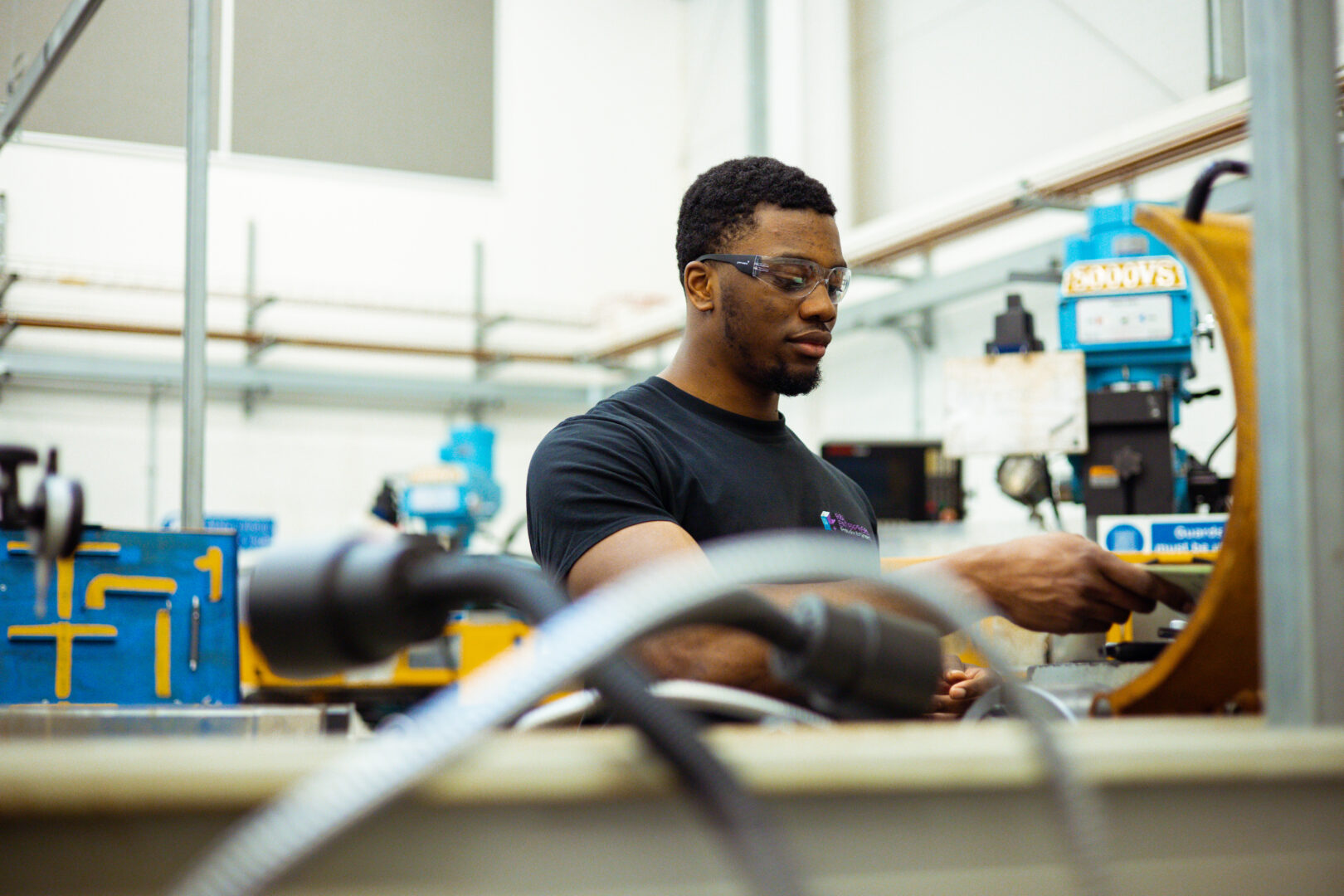 apprenticeships engineering student wearing safety glasses working with engineering equipment