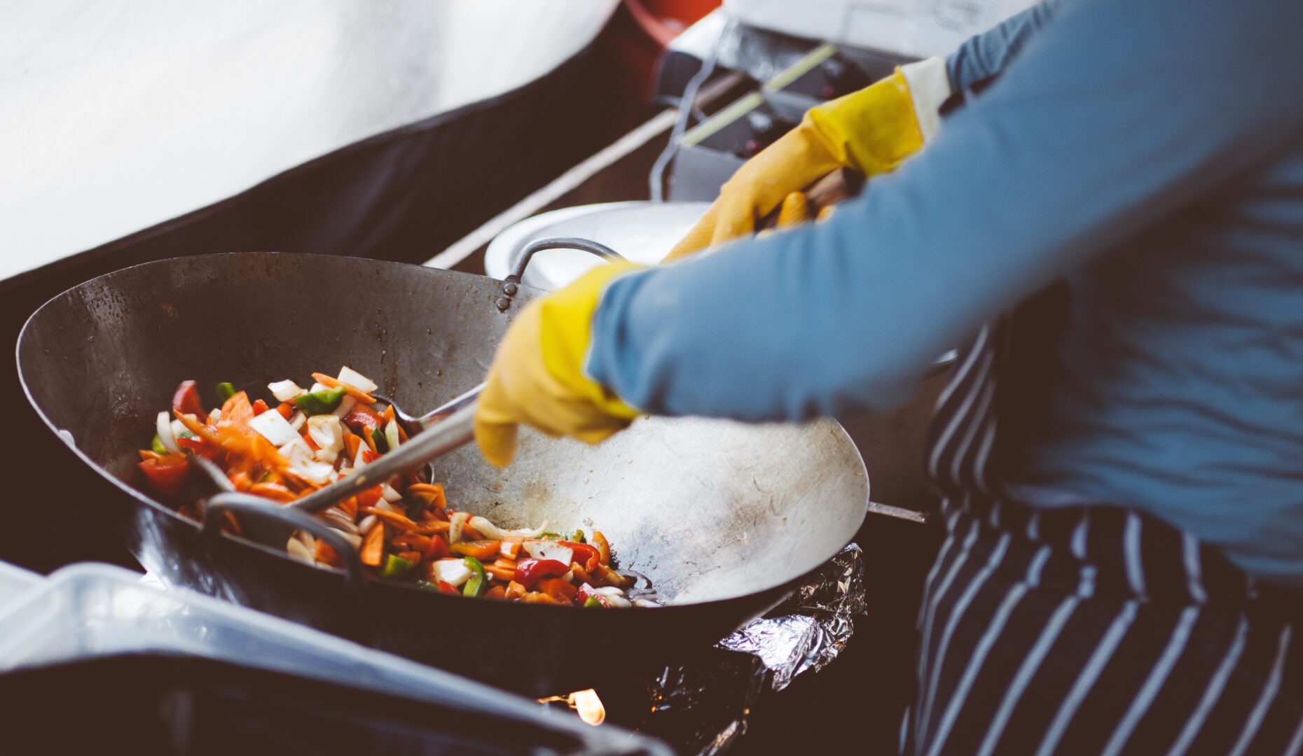 an image of a person using a wok to prepare a meal