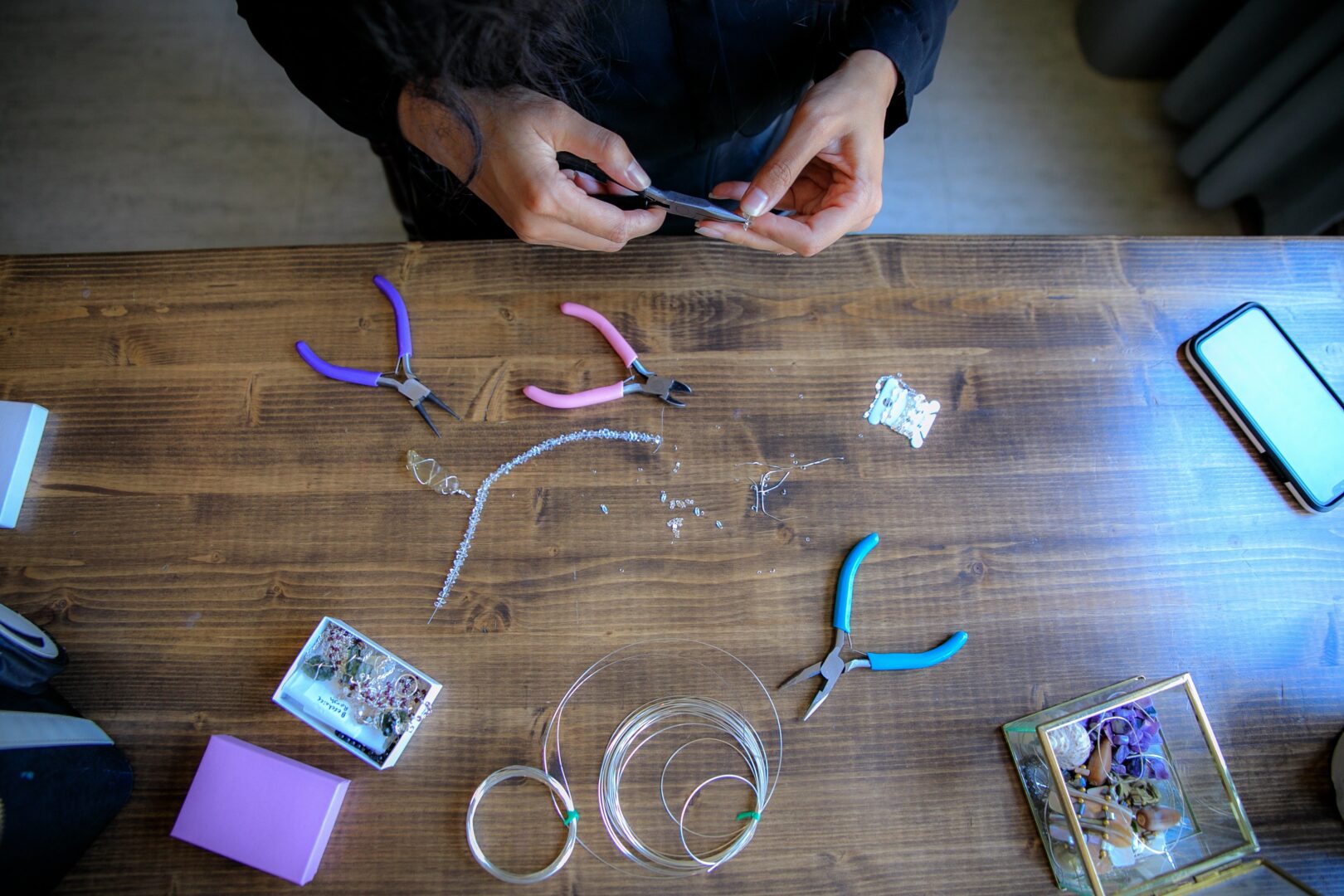 an image of hands using tools to create jewellery