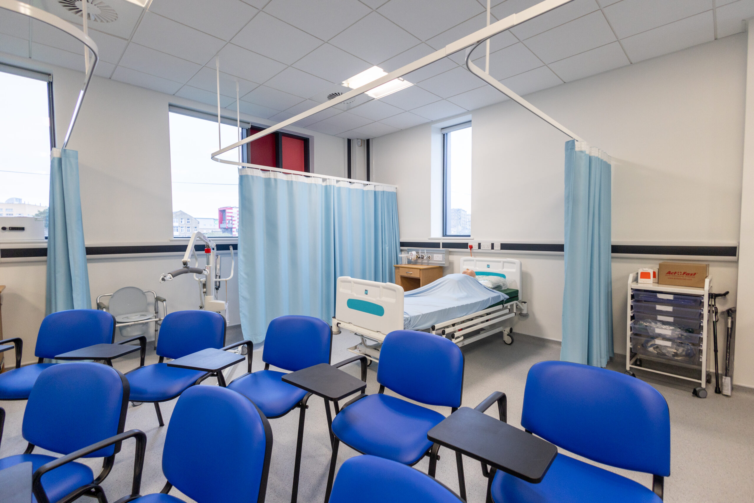 a nursing suite with curtains, hospital beds and surgical equipment