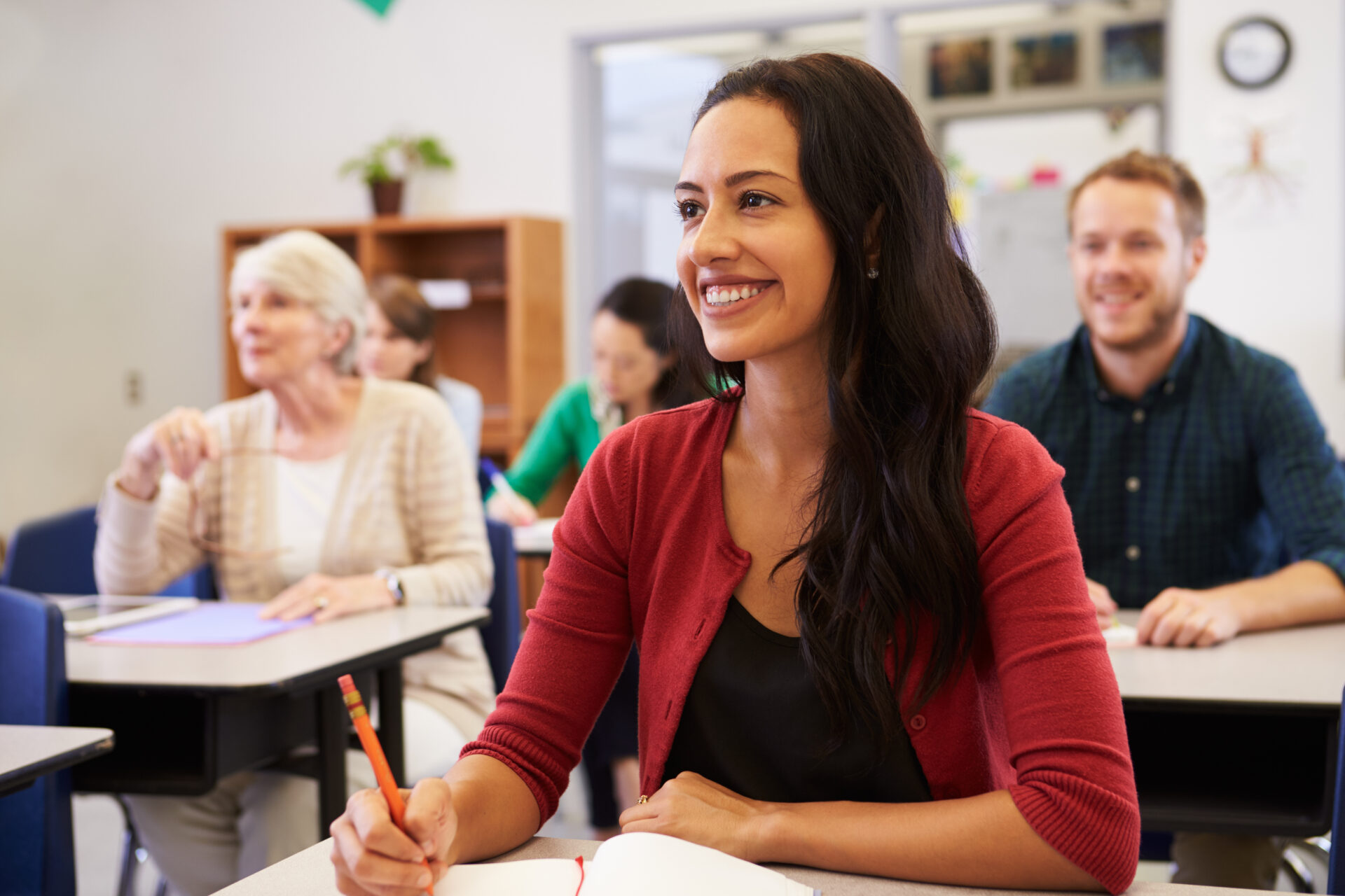 a student in a classroom at a desk smiling