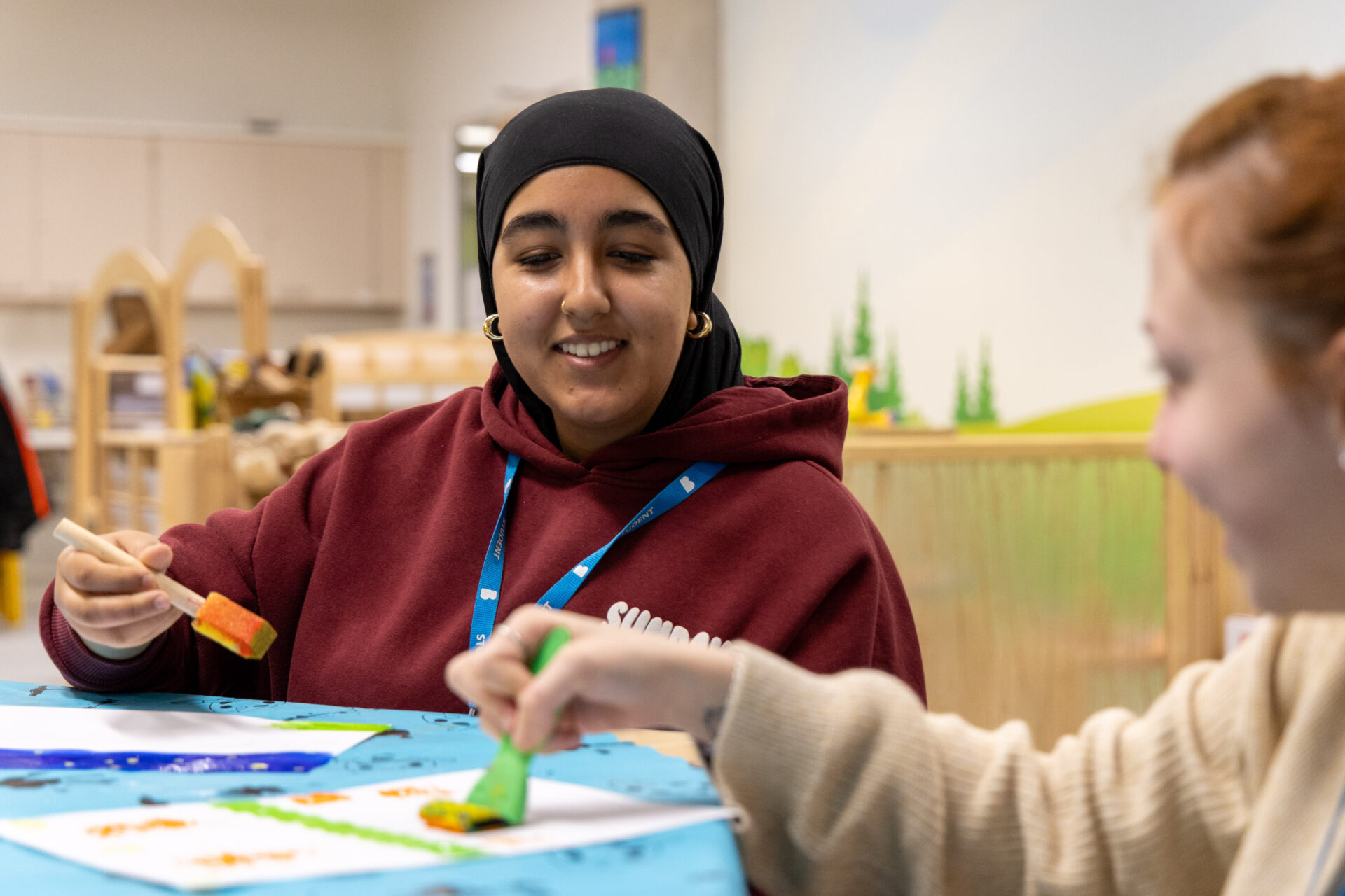 Female student smiling in our mock nursery facilities