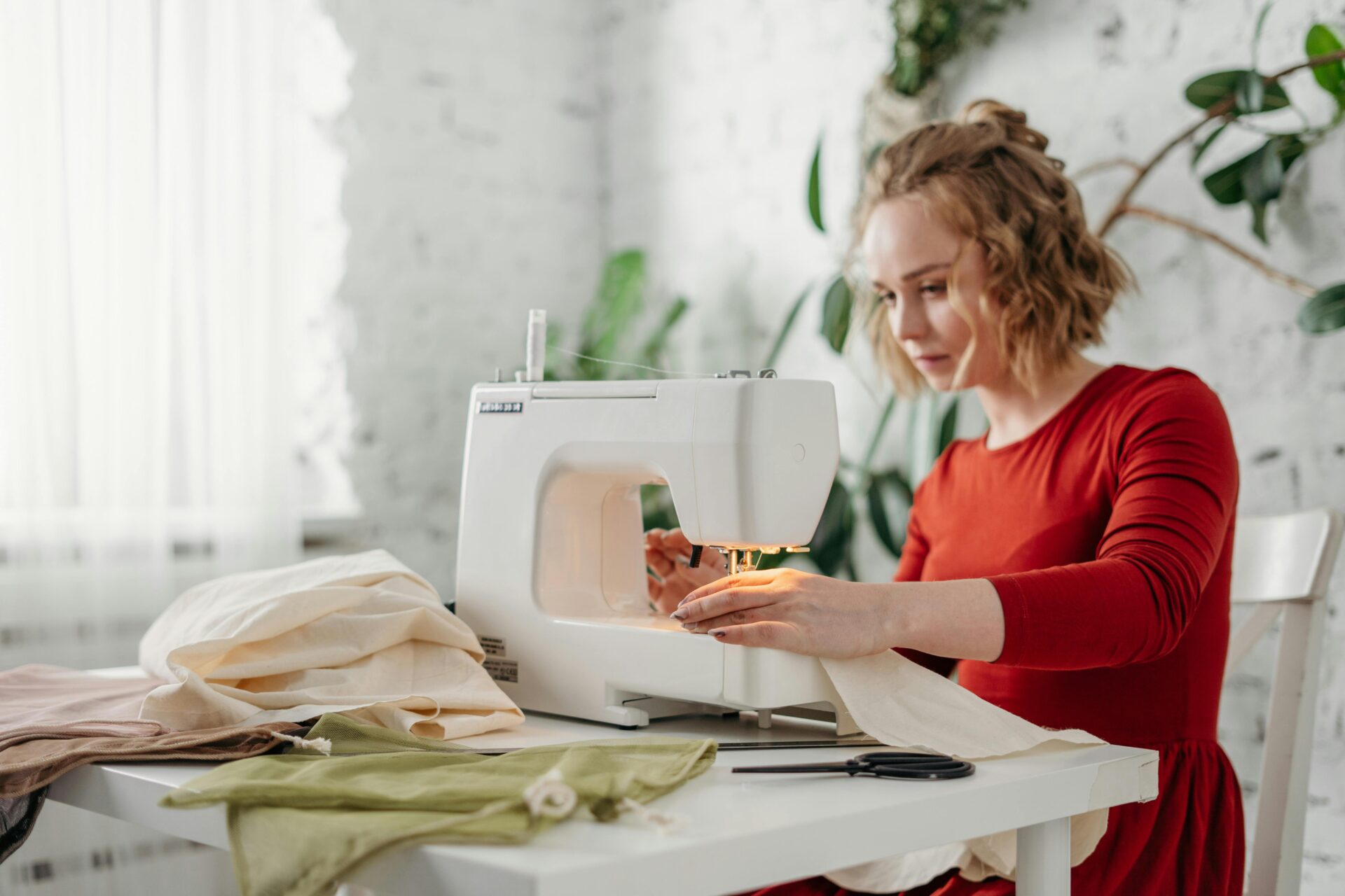 a woman sits at a sewing machine