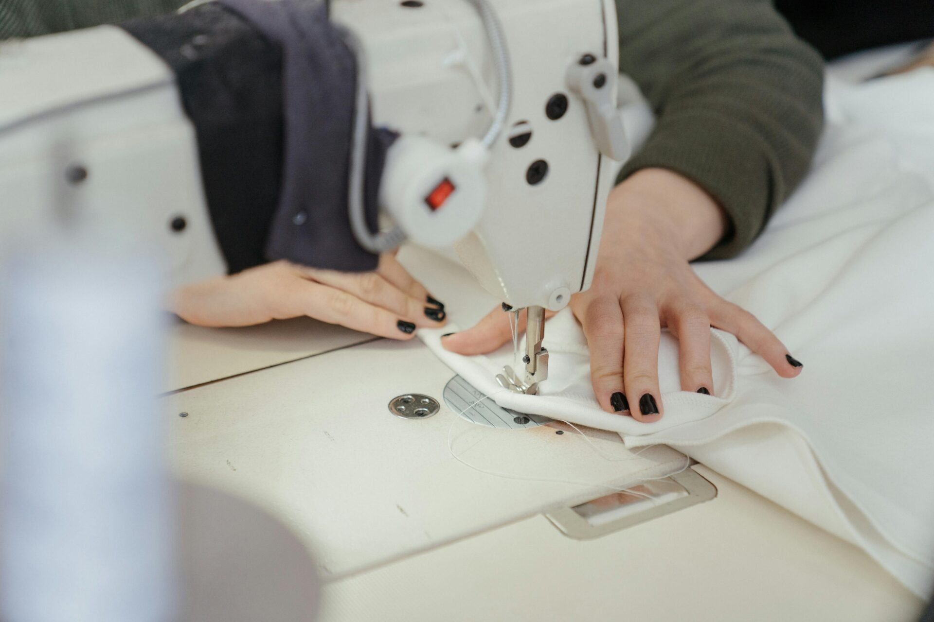 a woman sits sewing at a sewing machine