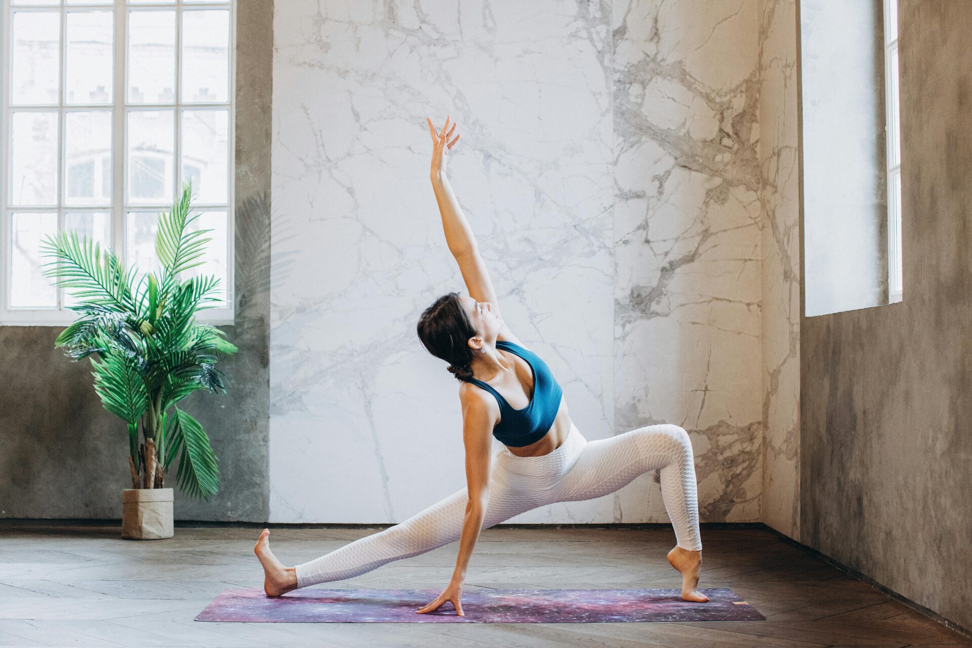 a woman practices a yoga pose in a yoga studio