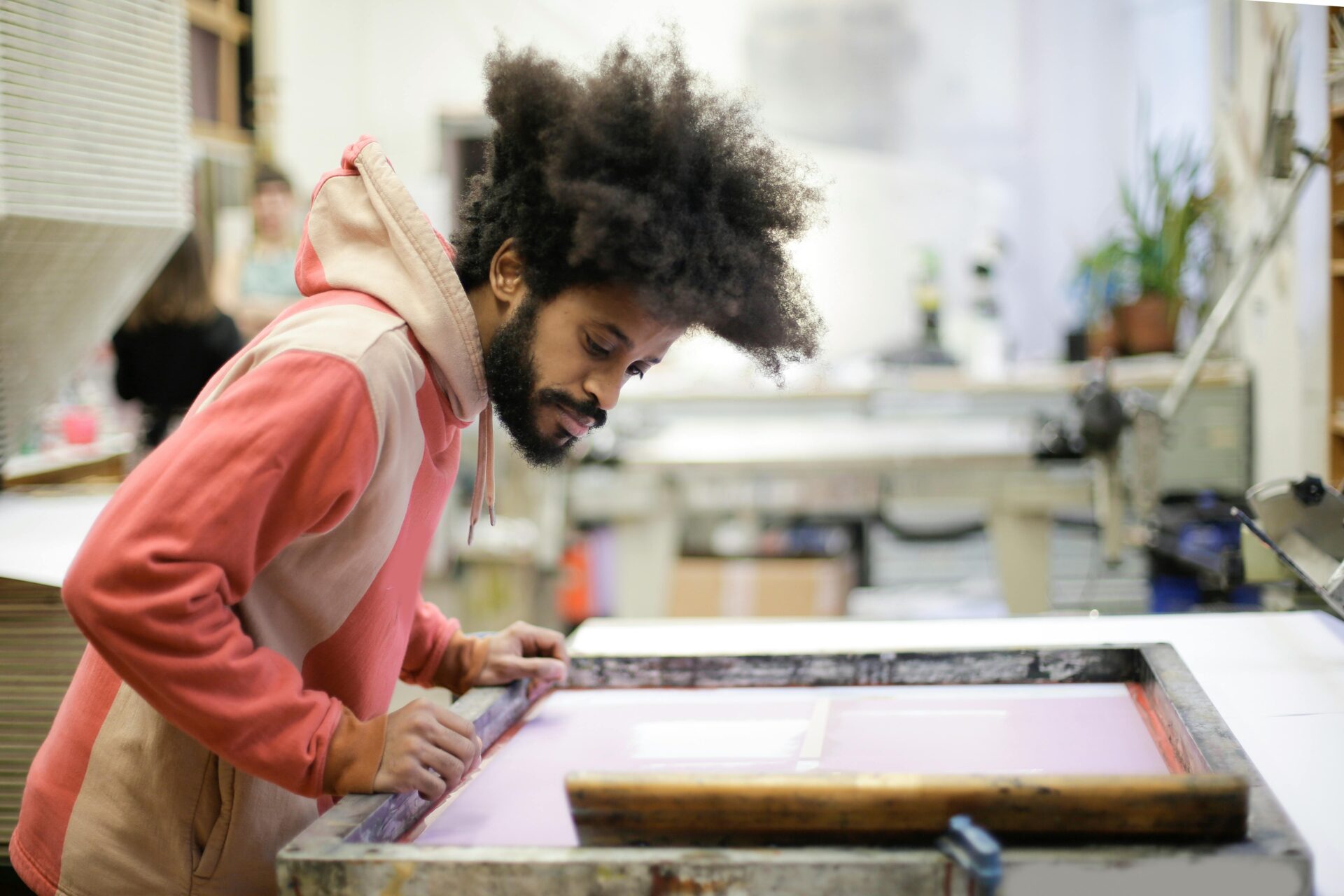 a student stands at the textile printing equipment