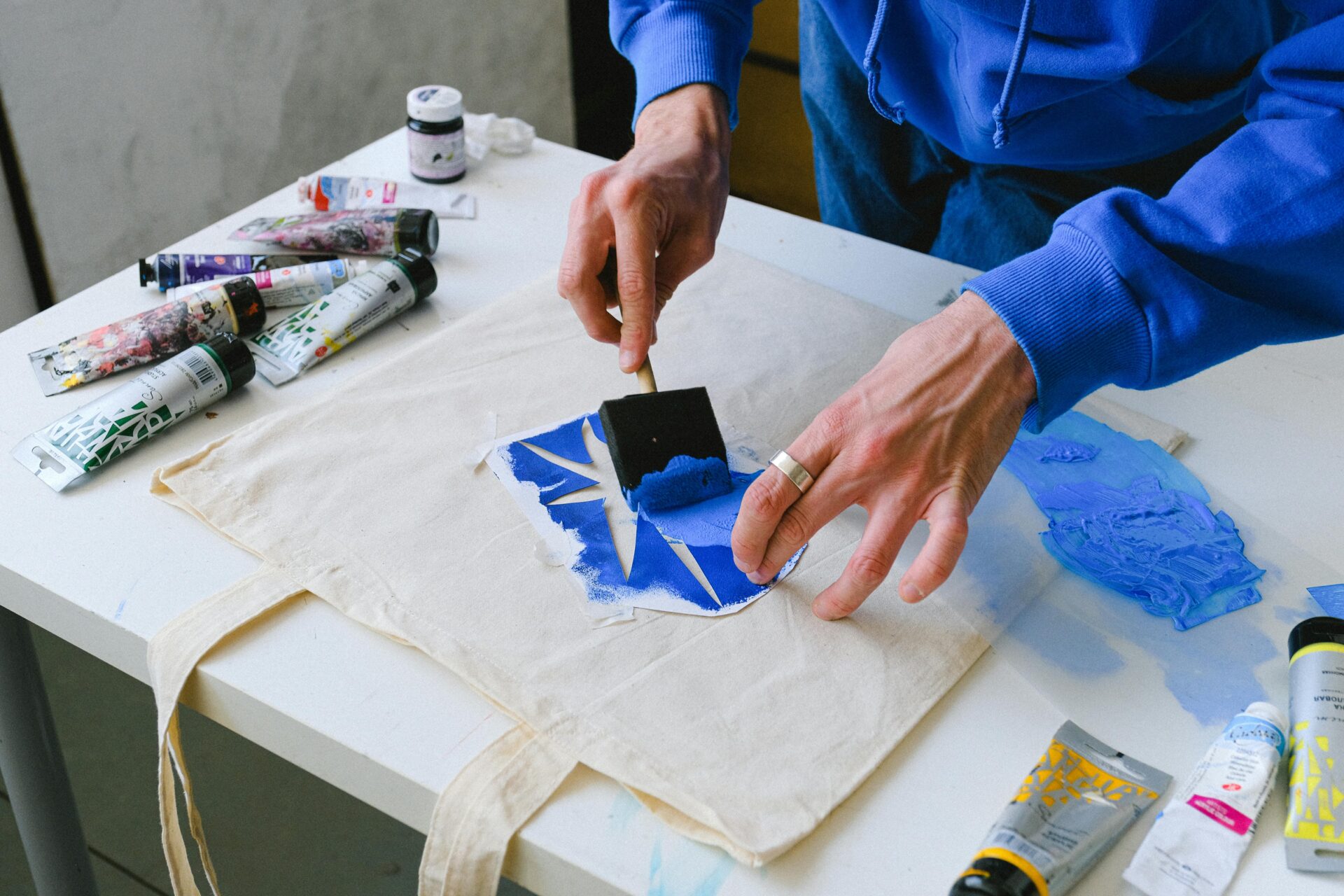 a person uses a brush to print a design on a textile material