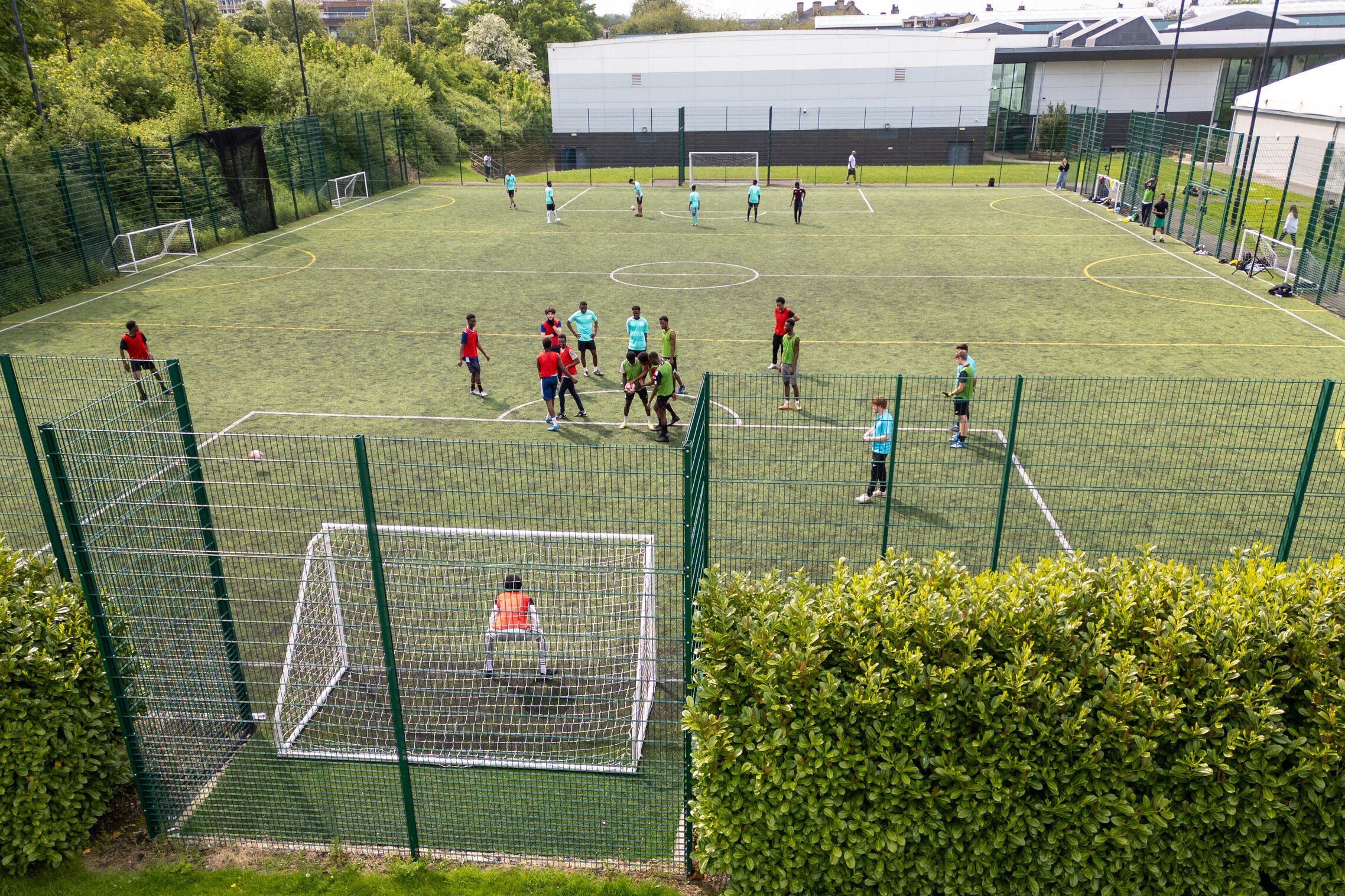 sports students stand on a pitch as they engage in a game of football