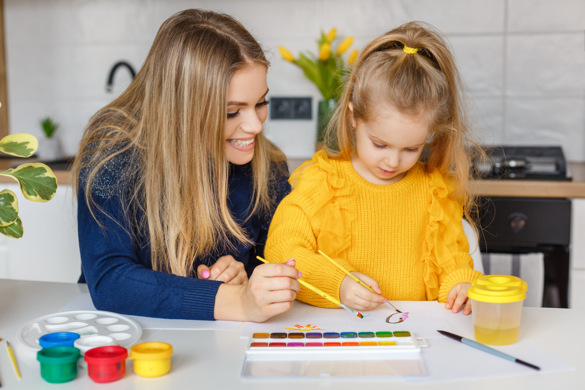 Young woman with young child doing an activity at a table