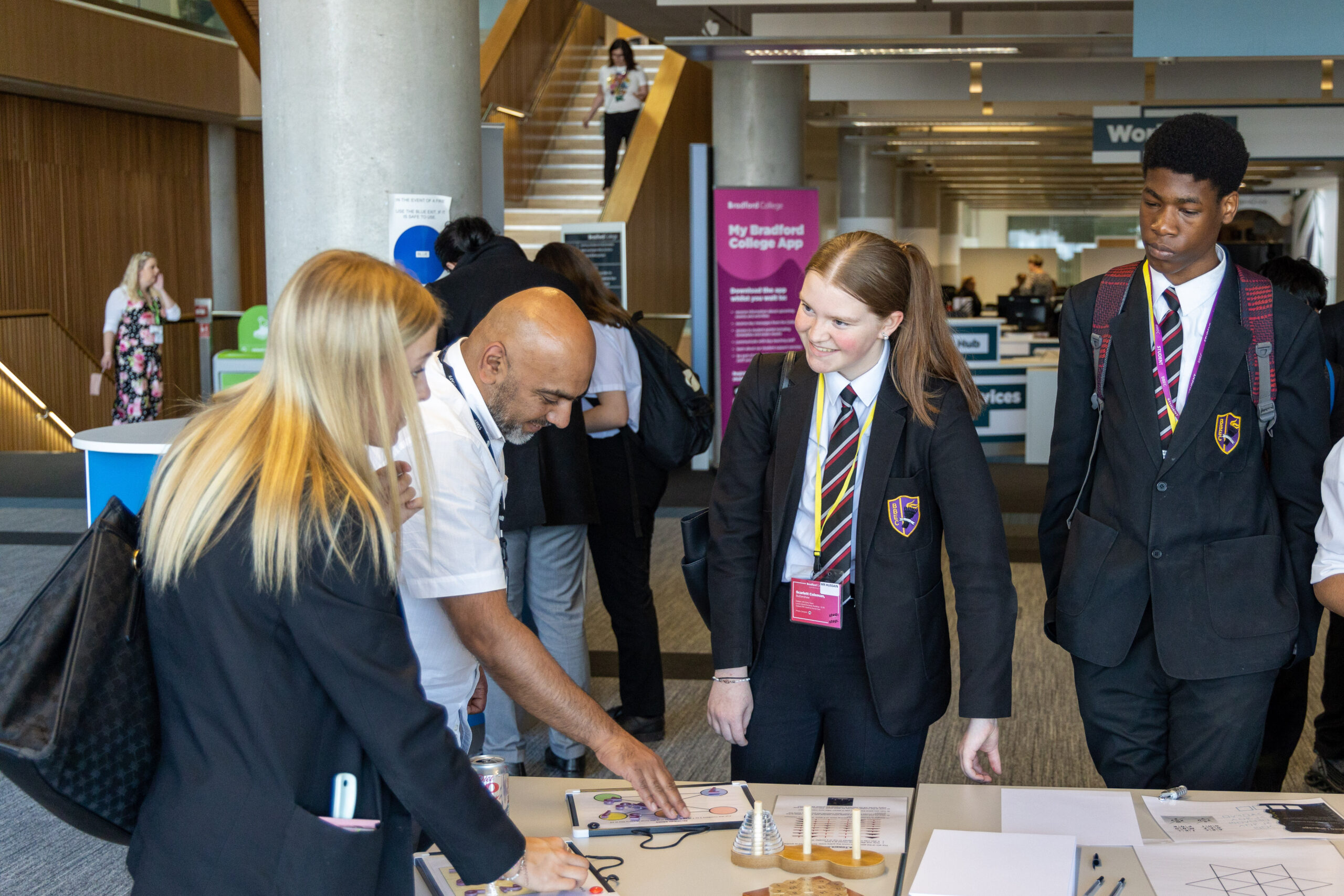 3 school students stand around a table with a tutor completing science activities