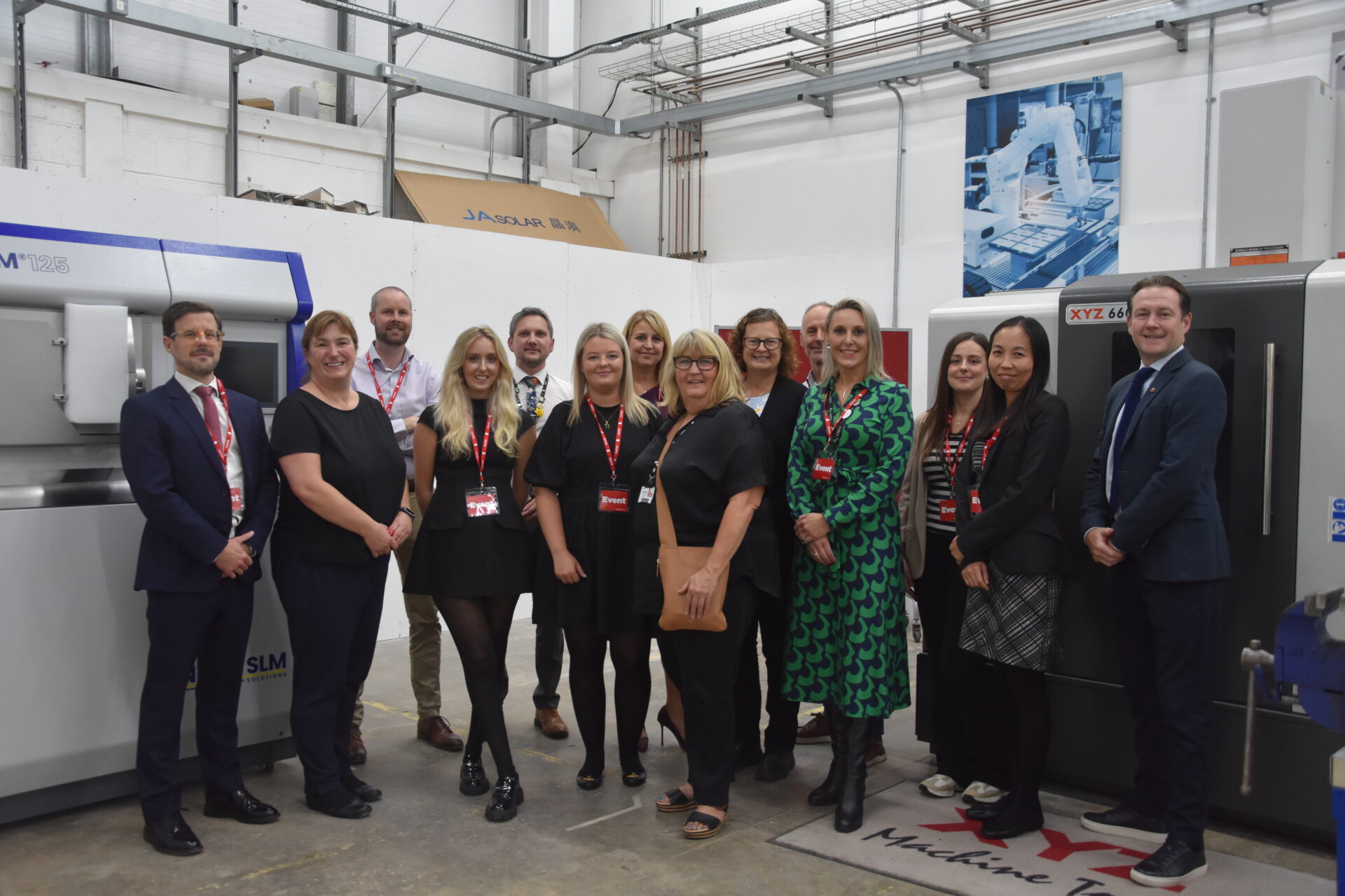 a group of people stand together in a manufacturing workshop