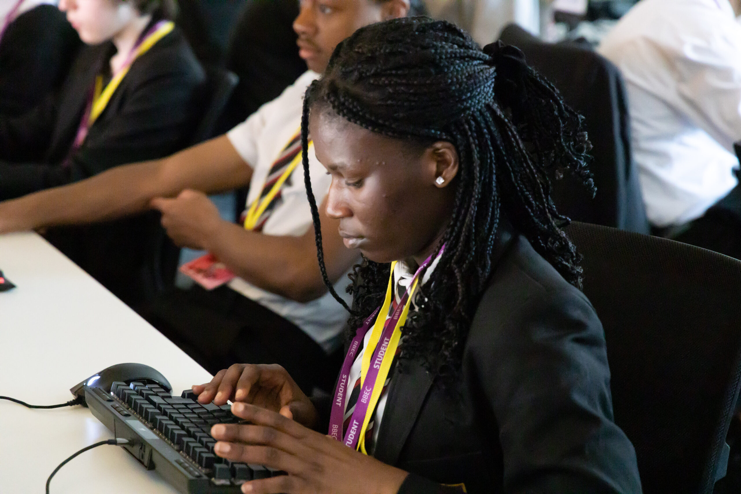 a black female student sits at a desk typing on a keyboard