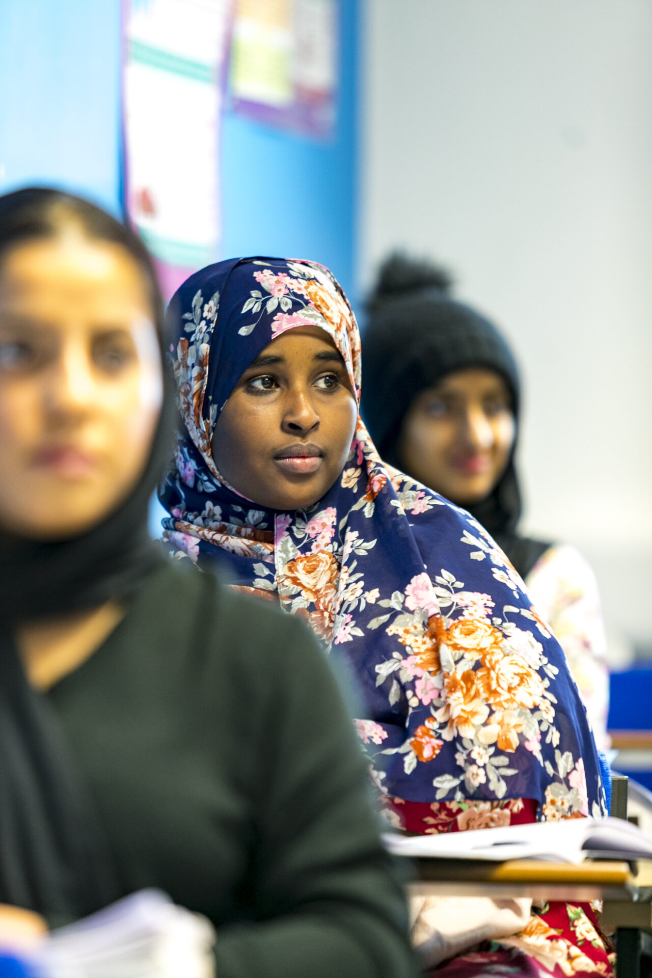 Female student in a head scarf sat at a desk in class