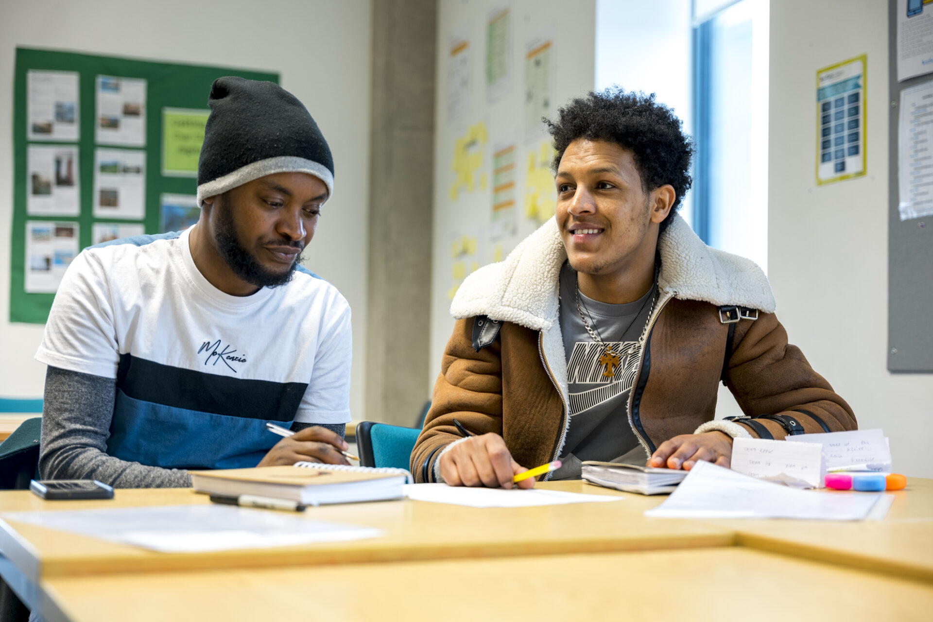 2 male students sat at a desk in class