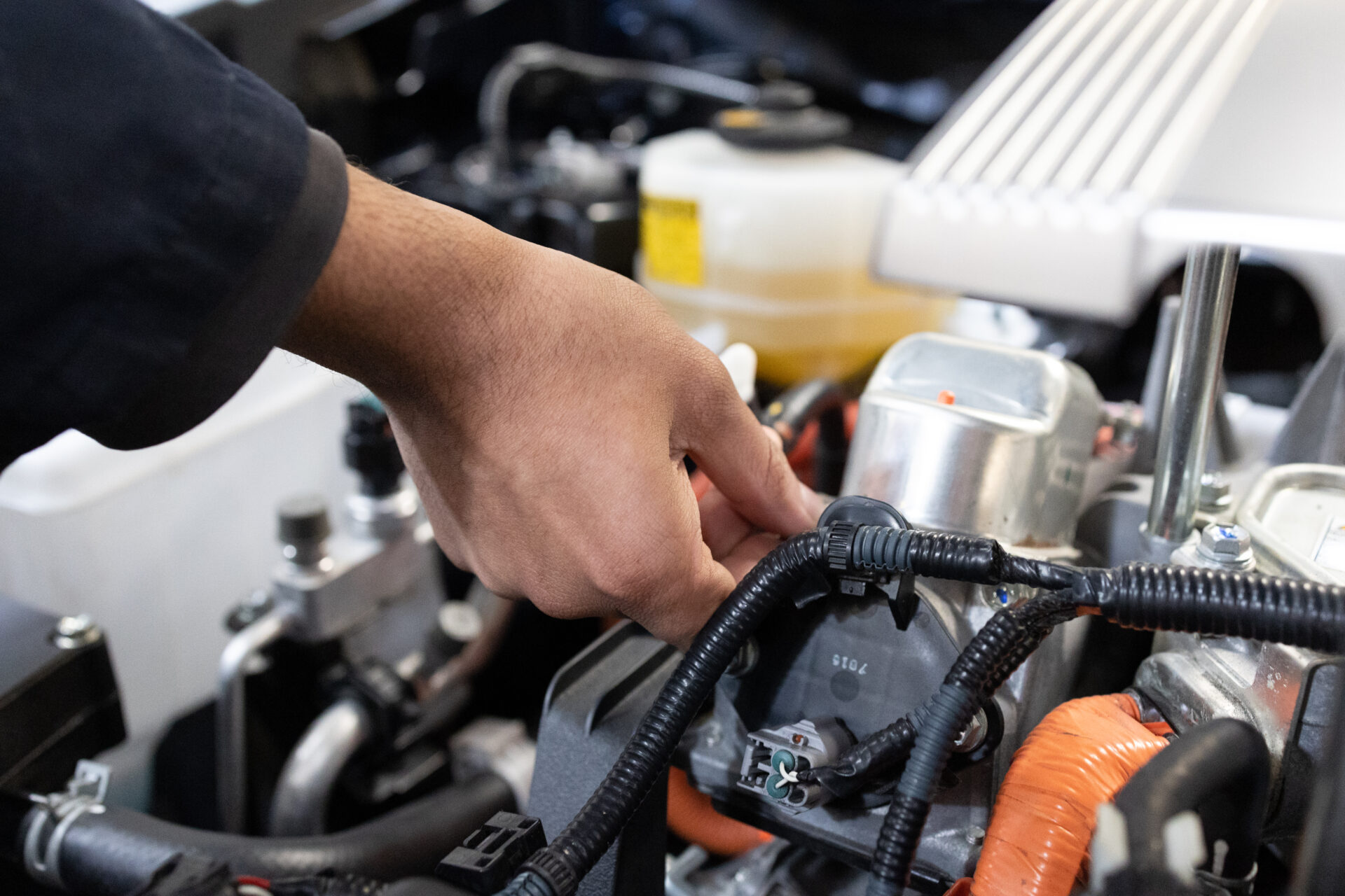 Hands repairing a hybrid engine