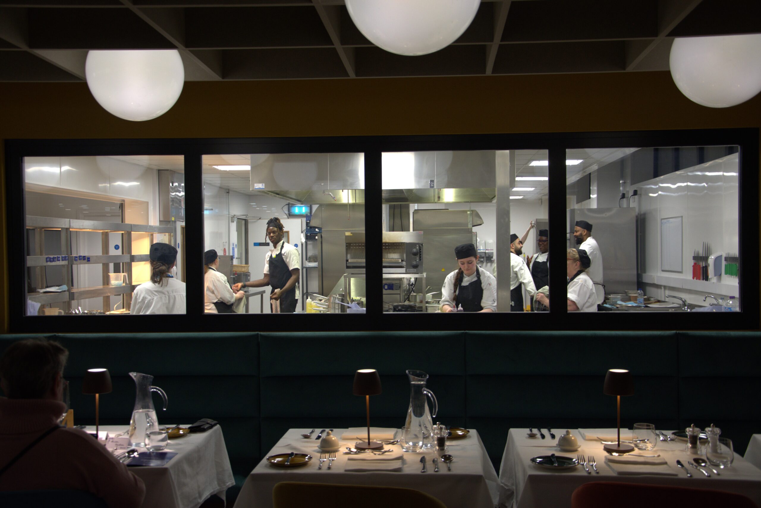 view from the restaurant of students working in the kitchen,