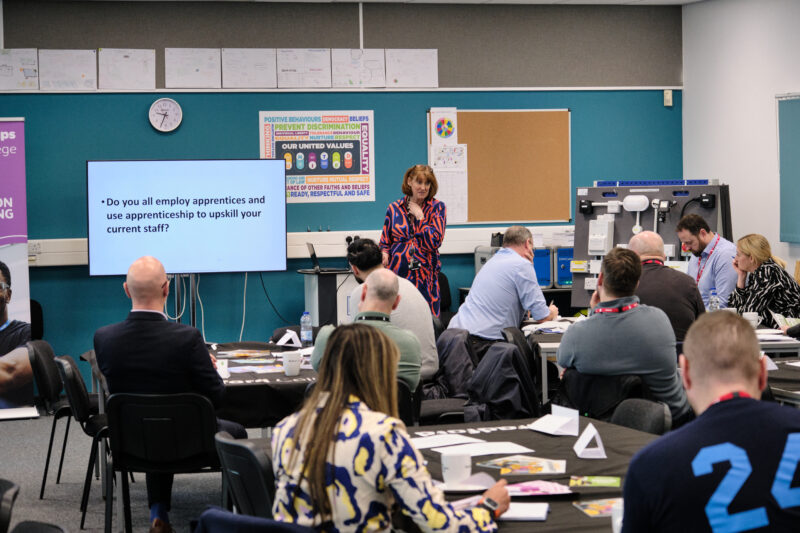 A group of people attending a presentation in a classroom setting.