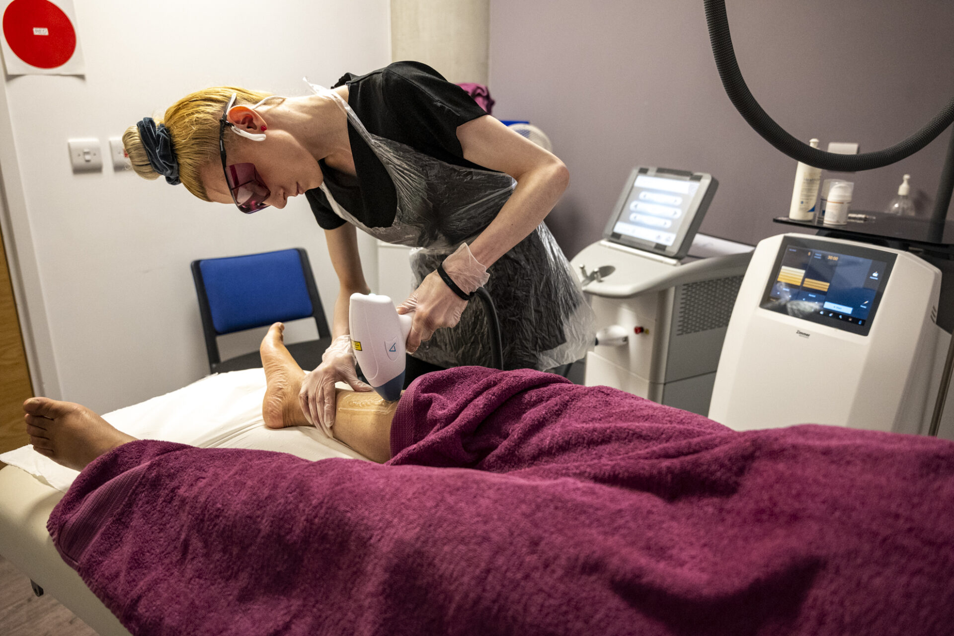 Female student using IPL equipment to remove hair on a leg